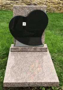 Petit monument funéraire en granit moucheté rose avec stèle en cœur noir poli.