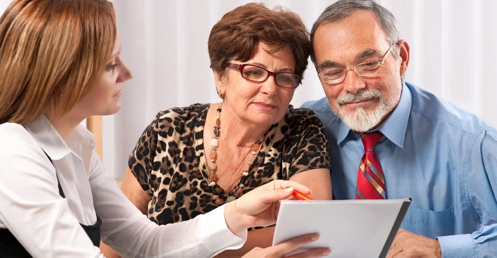 Conseillère présentant un contrat de prévoyance obsèques à un couple senior.