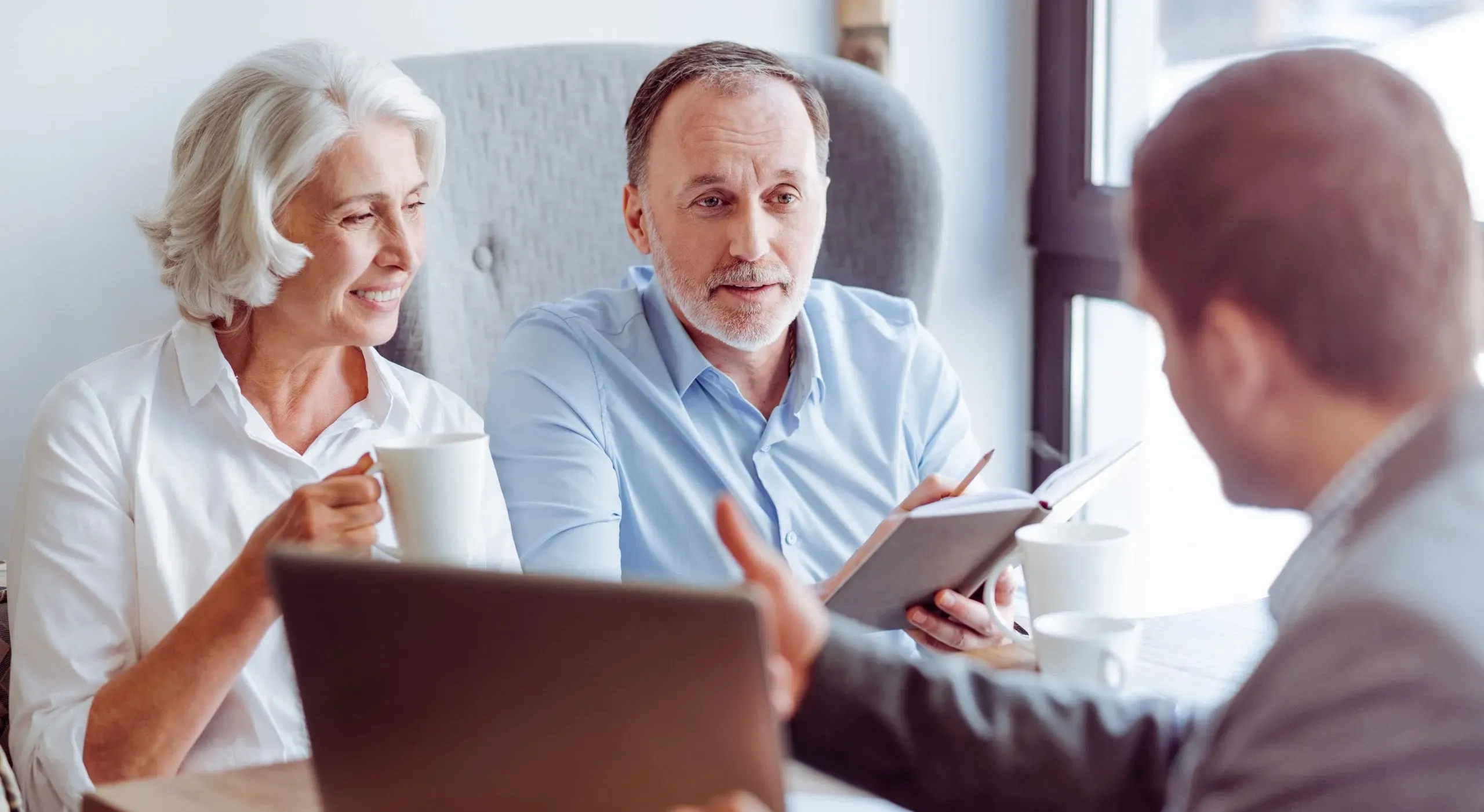 Couple de seniors en rendez-vous avec un conseiller funéraire.
